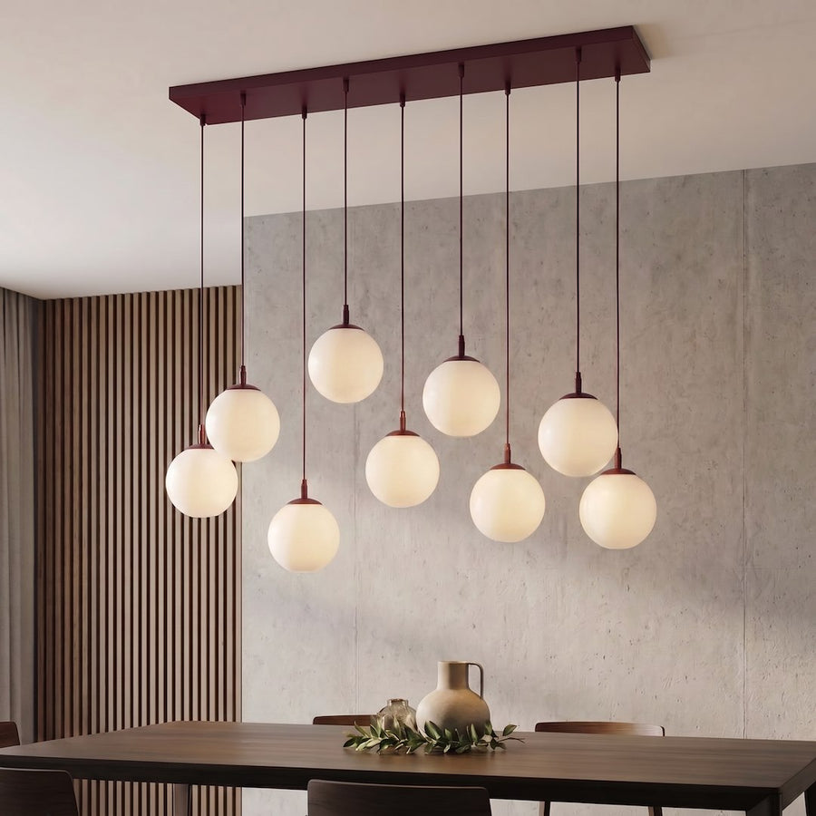 Luminaire installé au-dessus d'une table en bois, mur béton et claustra vertical en bois