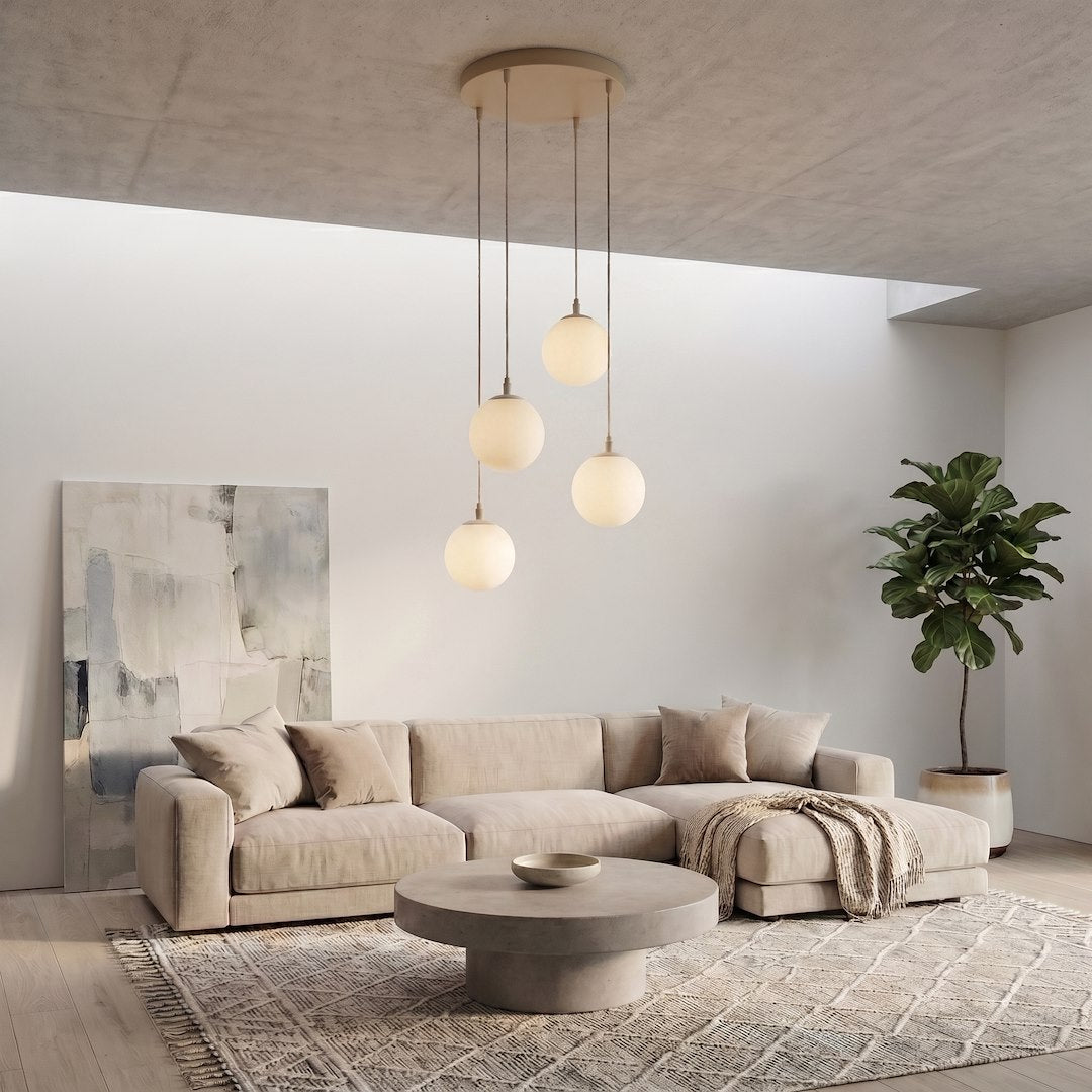 Mise en ambiance dans un salon, canapé beige, globes lumineux au-dessus du coin repos