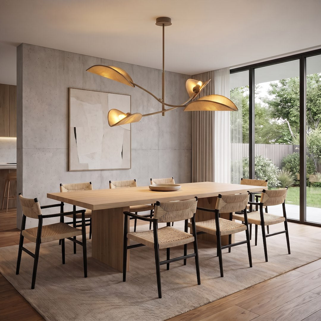 Luminaire suspendu allumé au-dessus d'une table en bois, chaises tressées, salle à manger
