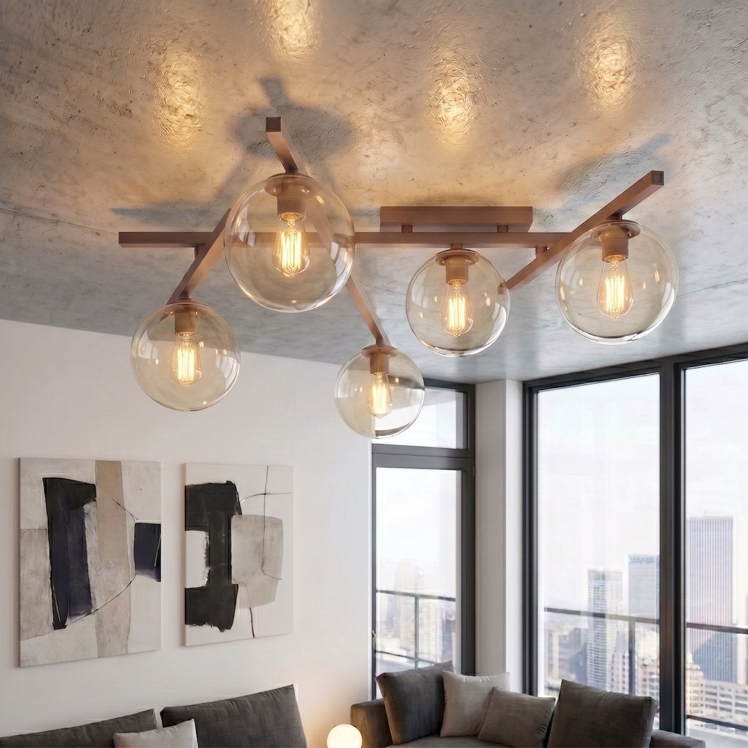 Mise en ambiance sous plafond béton, cinq globes allumés près d'une baie vitrée.