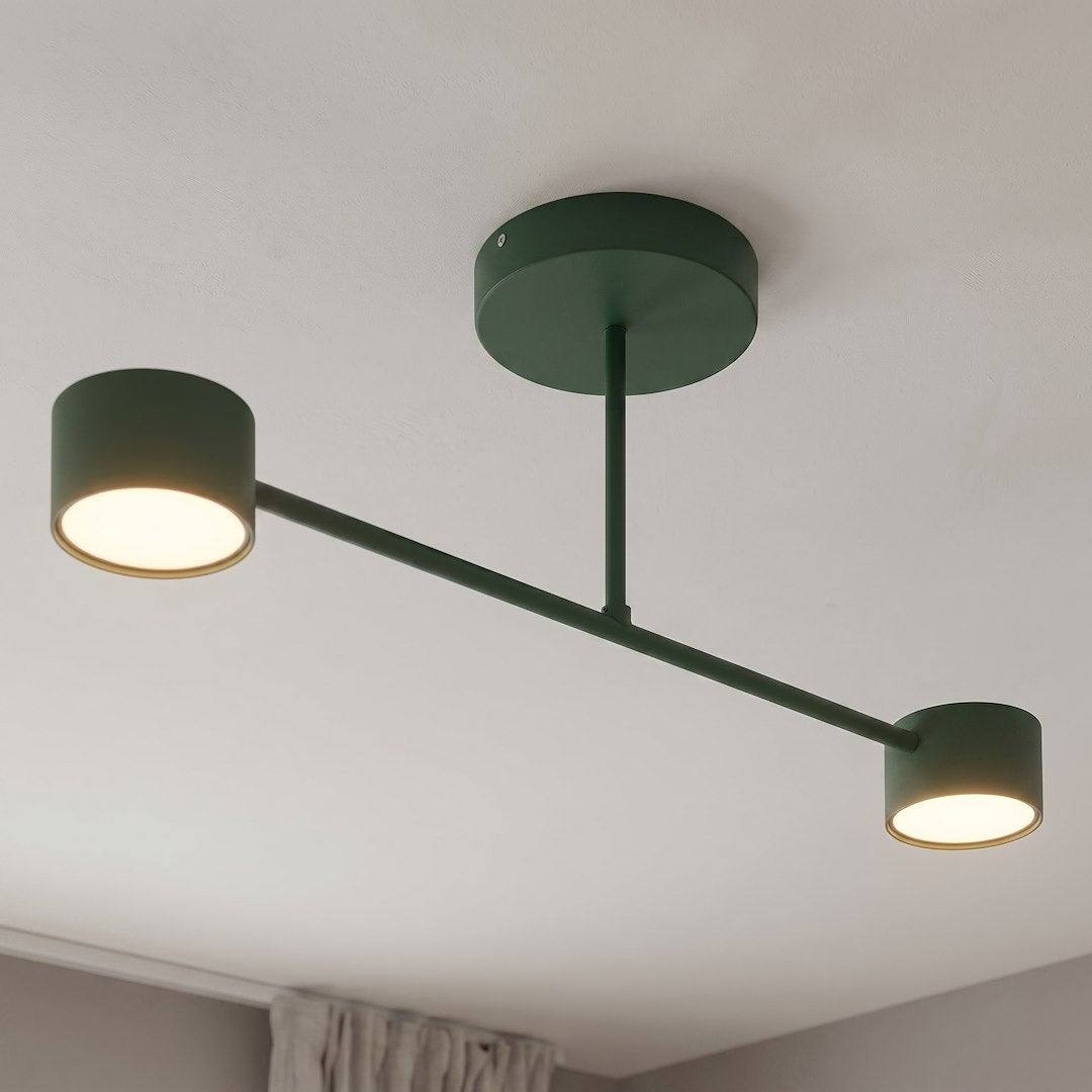 Détail rapproché des deux têtes cylindriques allumées sous un plafond blanc.