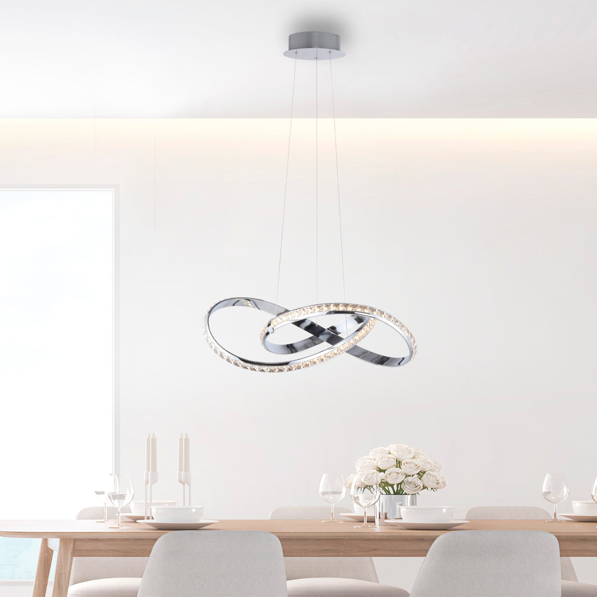Mise en ambiance : suspension allumée au-dessus d'une table à manger en bois clair et chaises.