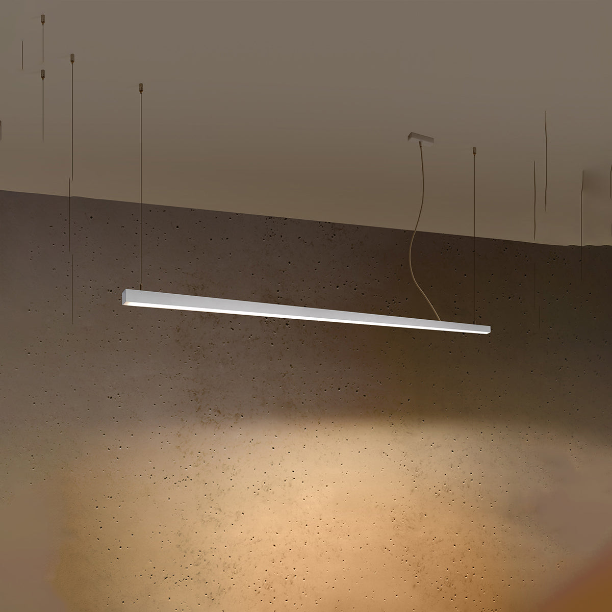 Mise en ambiance nocturne, halo lumineux chaud projeté sur le mur béton