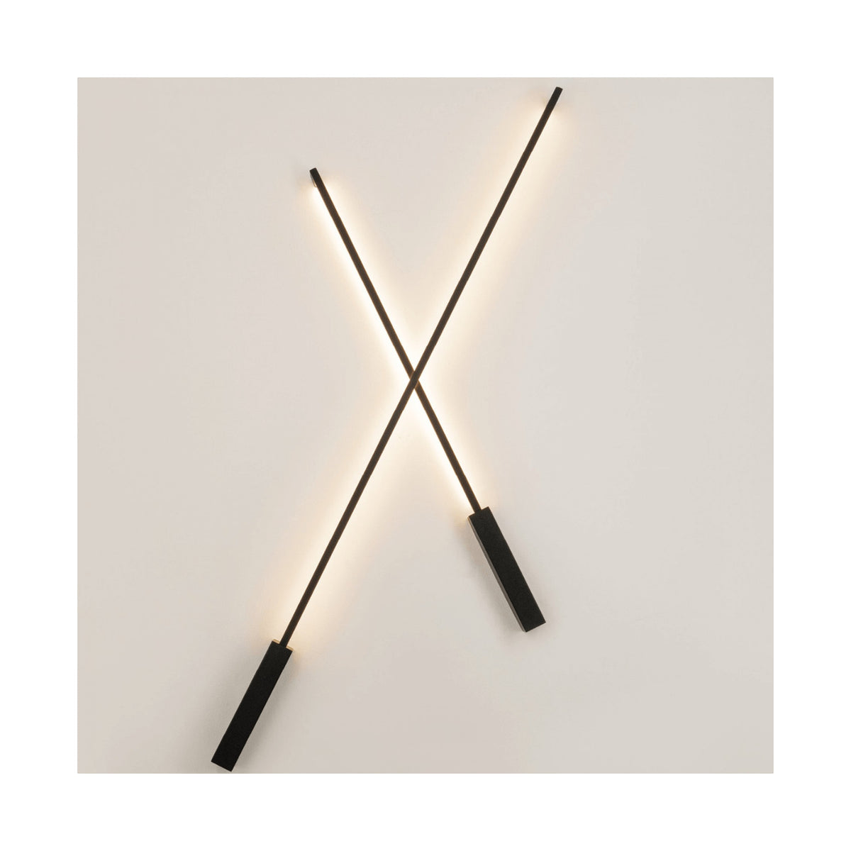 Applique murale design en X, deux tiges noires fines avec socles rectangulaires et halo lumineux.