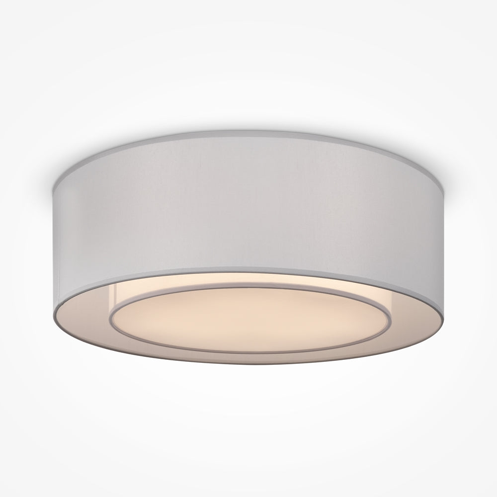 Plafonnier argenté vu de face, abat-jour cylindrique en tissu diffusant une lumière chaude