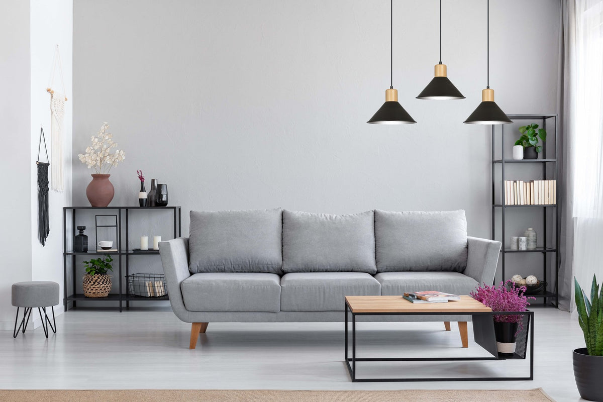 Mise en ambiance dans un salon gris avec canapé, étagères et table basse.