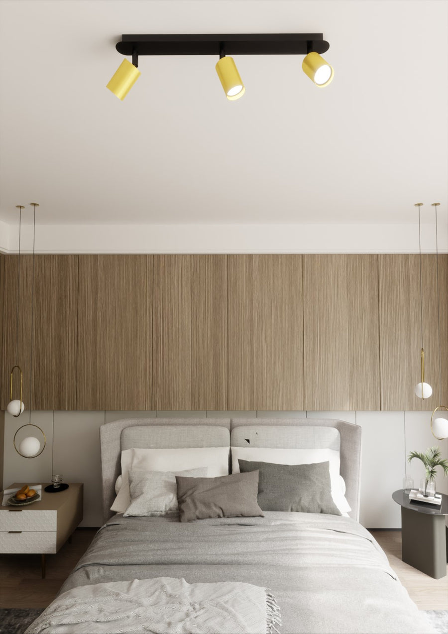 Plafonnier fixé au plafond d'une chambre, tête de lit en bois clair et lit gris