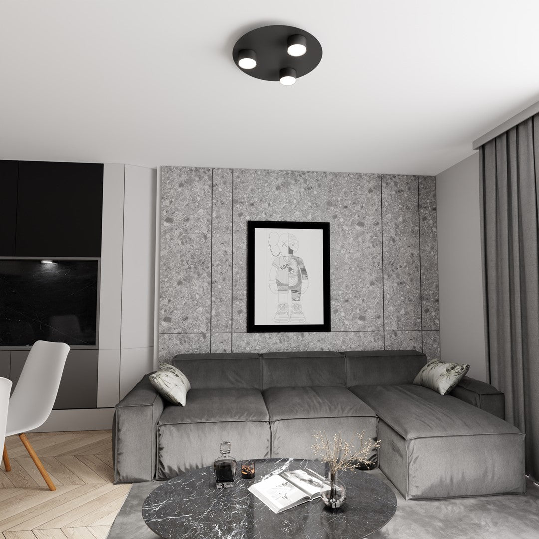 Mise en ambiance dans un salon gris avec canapé d'angle et tableau.
