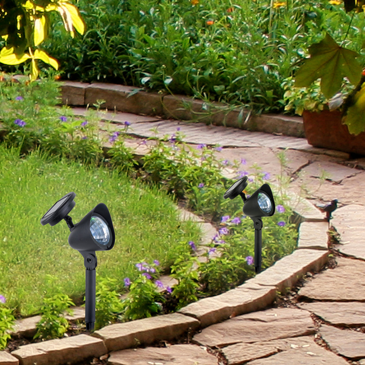 Mise en ambiance de deux piquets lumineux plantés le long d'une bordure