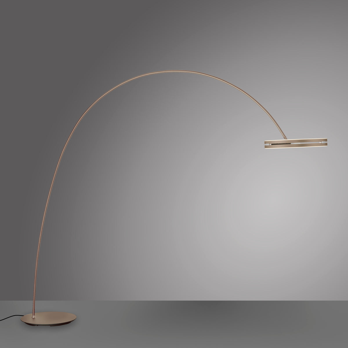 Lampadaire au long bras arqué cuivré terminé par une tête plate, sur fond gris.
