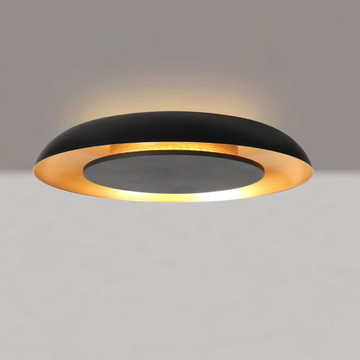 Plafonnier circulaire allumé au plafond diffusant une lueur chaude et dorée.