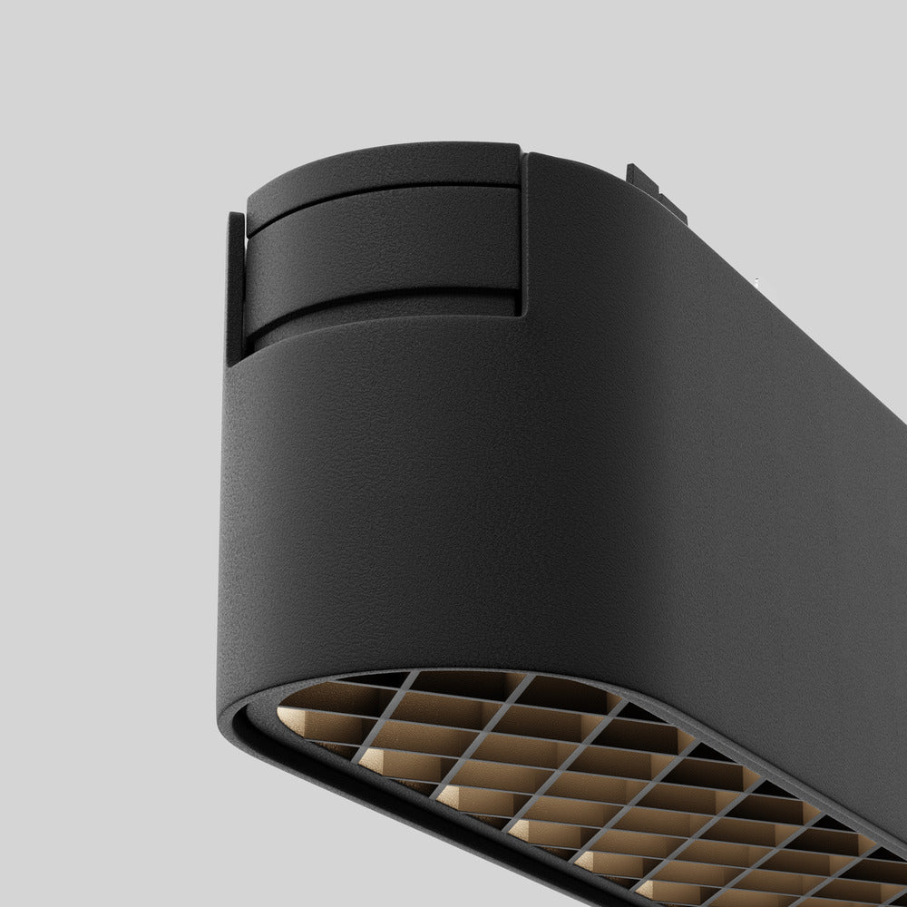 Gros plan du boîtier noir mat et de sa grille alvéolée dorée