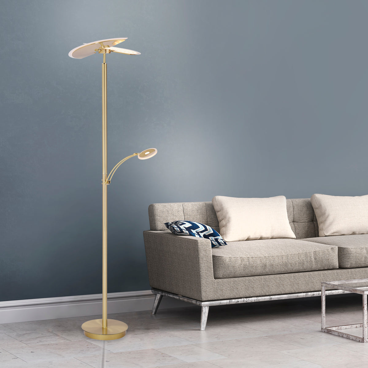 Mise en ambiance : lampadaire allumé près d'un canapé gris devant un mur bleu-gris.