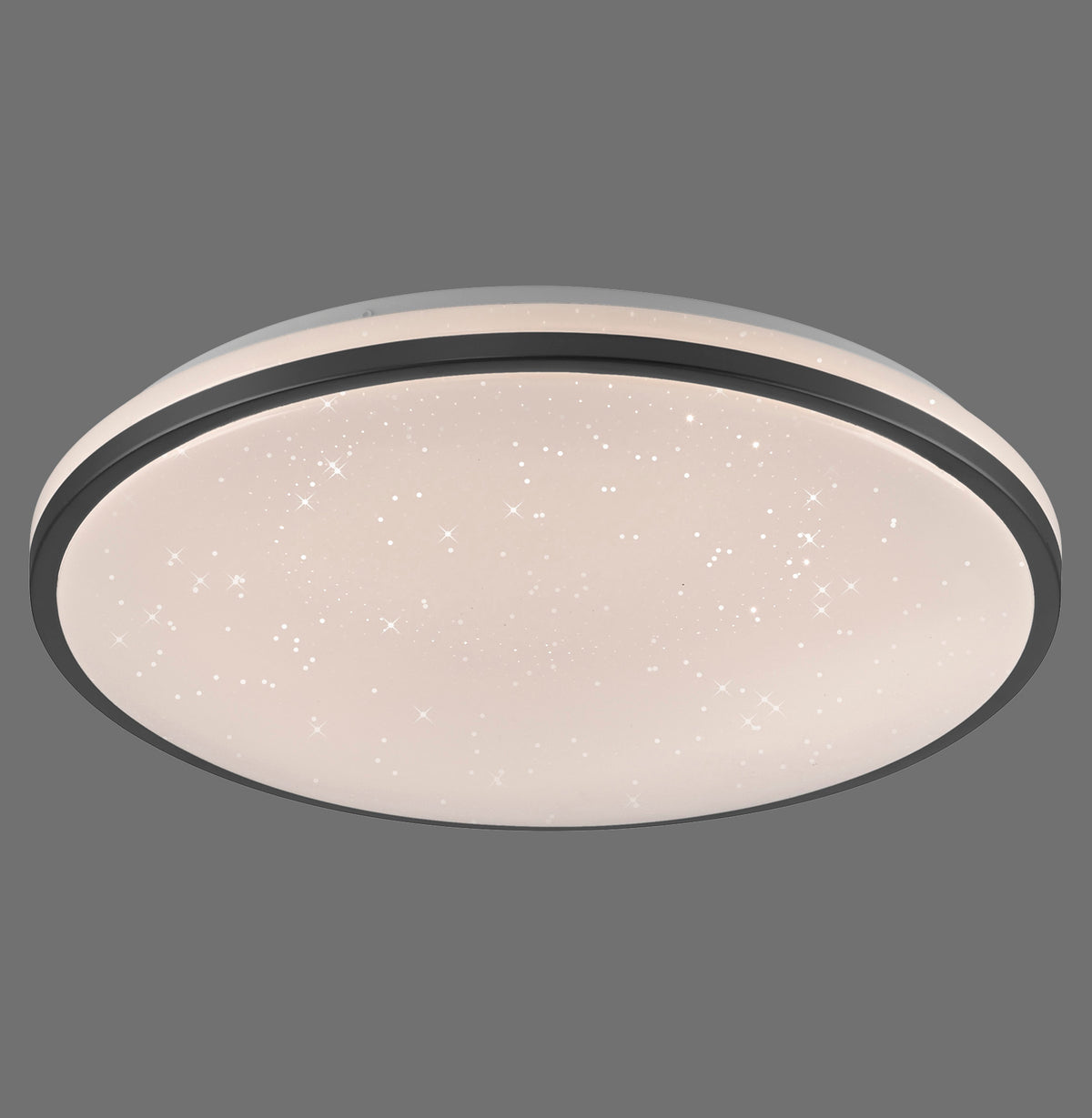 Luminaire rond de plafond allumé, bordure noire et diffuseur étoilé, sur fond gris.