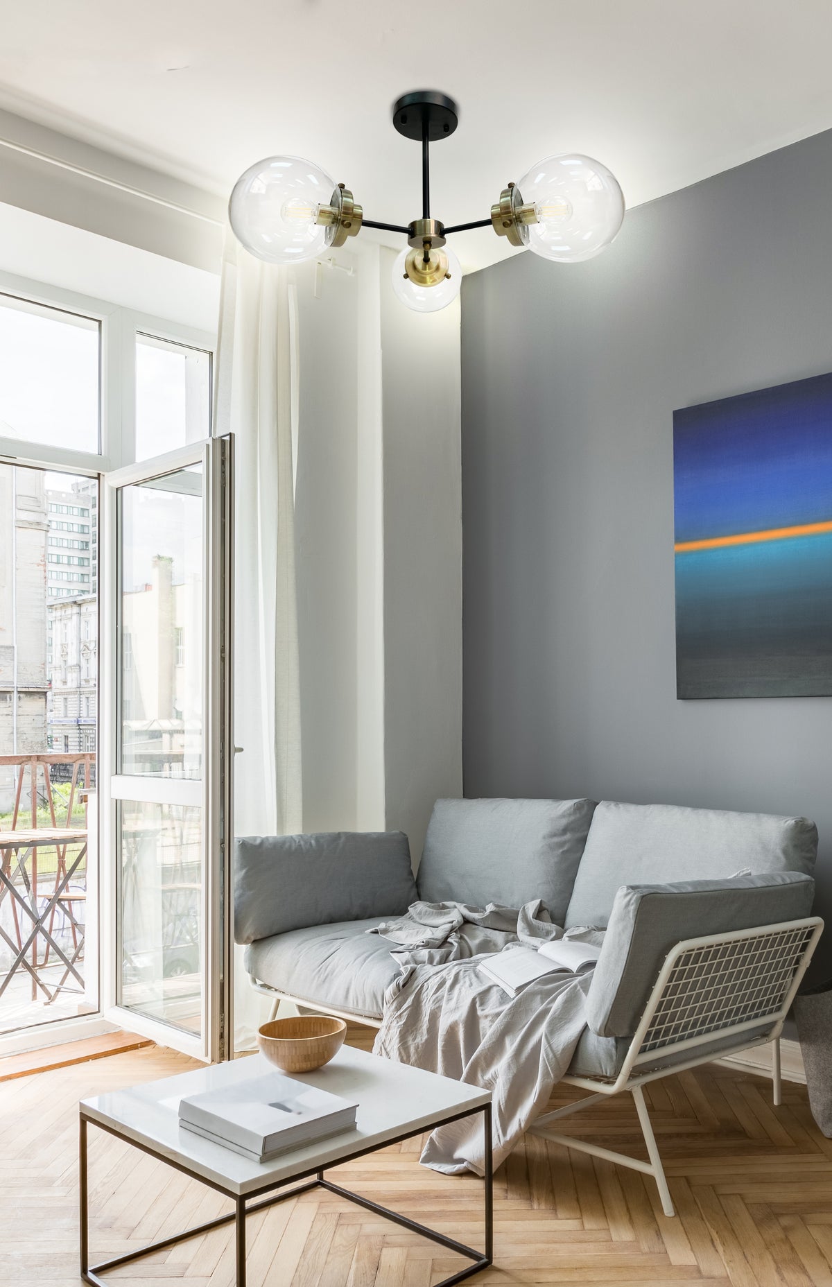Luminaire allumé au plafond au-dessus d'un canapé gris en salon contemporain