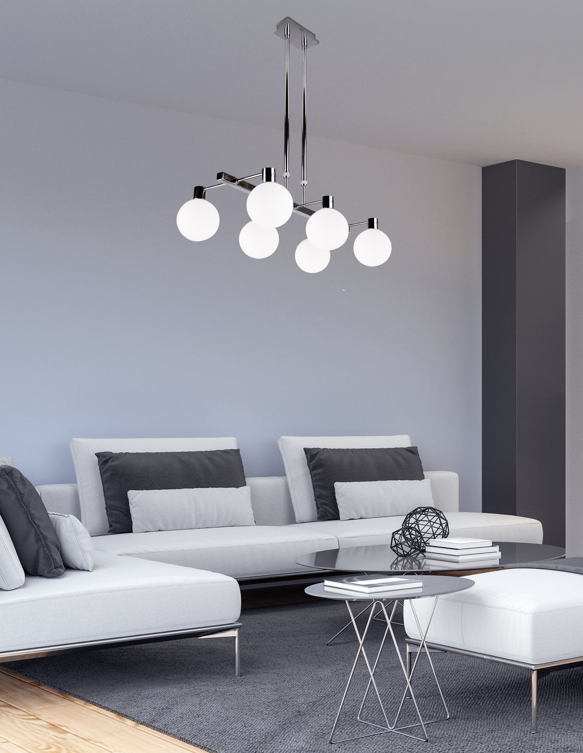Luminaire suspendu allumé au-dessus d'un canapé blanc dans un salon contemporain gris
