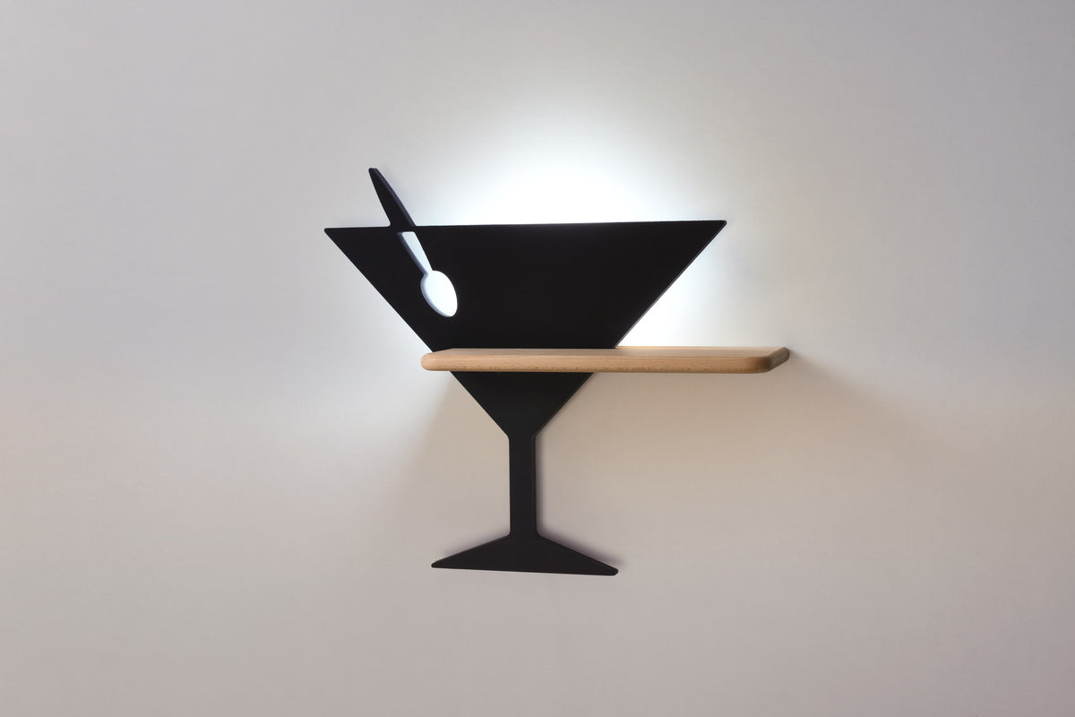 Applique noire installée au mur, éclairage allumé créant un halo lumineux.