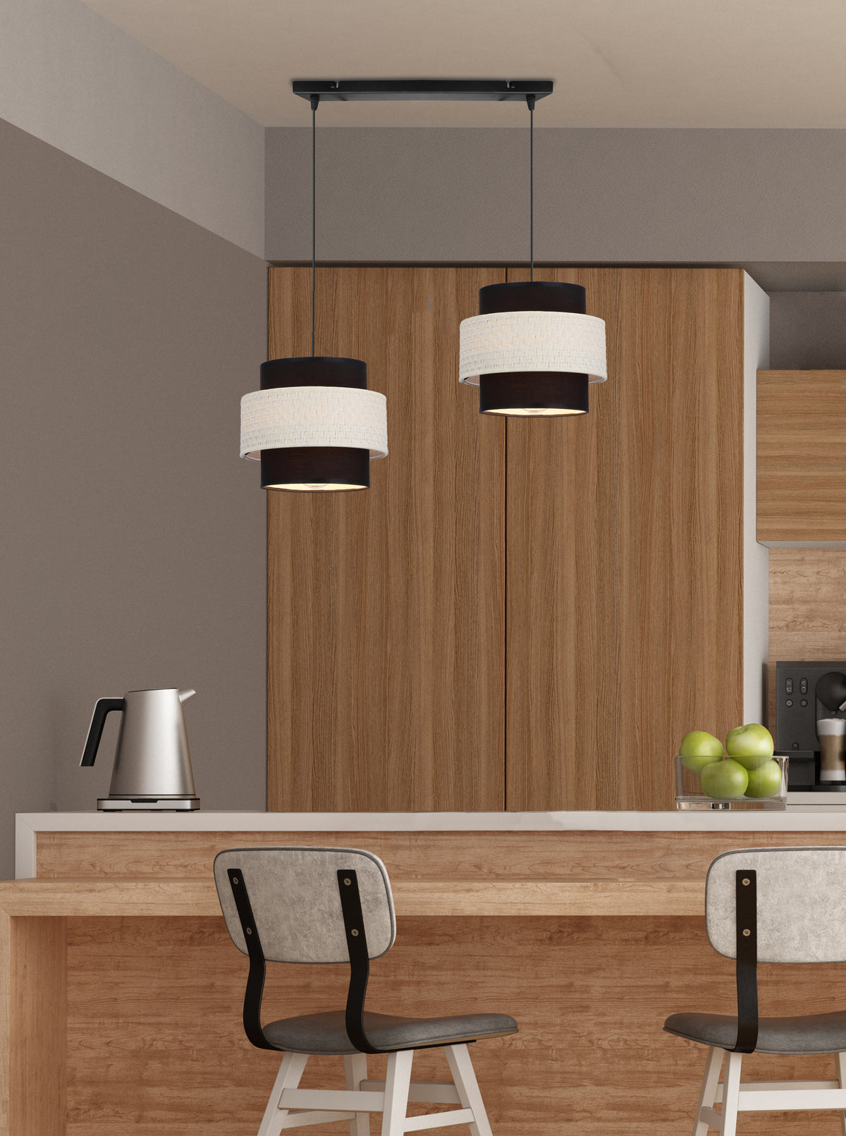 Suspension noire et crème installée au-dessus d'un îlot de cuisine en bois clair avec tabourets