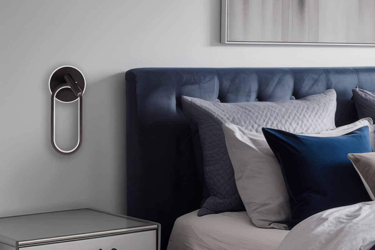 Mise en ambiance chambre, applique murale noire fixée près d'une tête de lit bleue