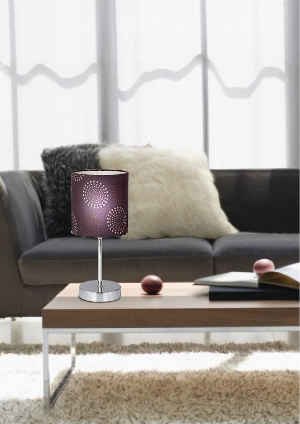 Vue rapprochée du salon montrant la lampe éclairée sur la table basse et son motif.