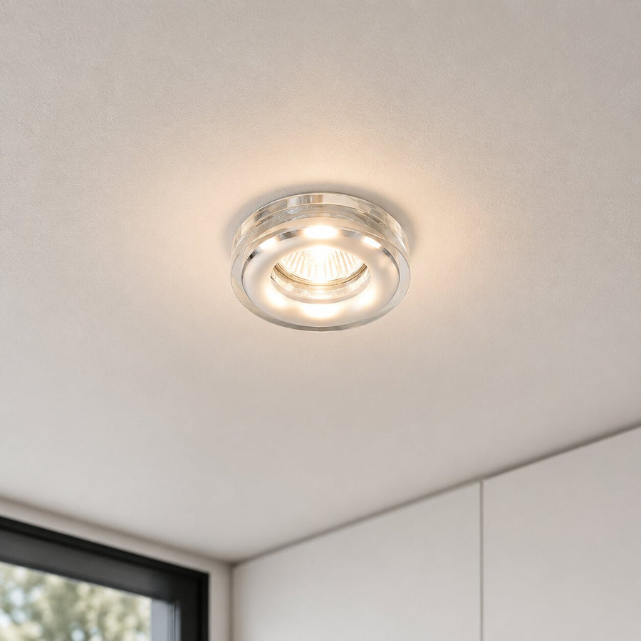 Spot allumé encastré dans un plafond blanc, éclairant une pièce moderne