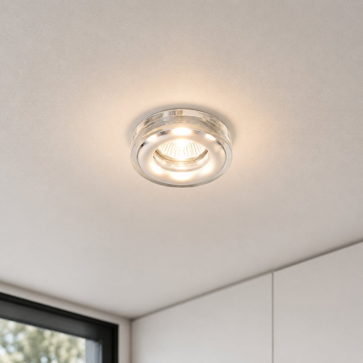Spot allumé encastré dans un plafond blanc, éclairant une pièce moderne