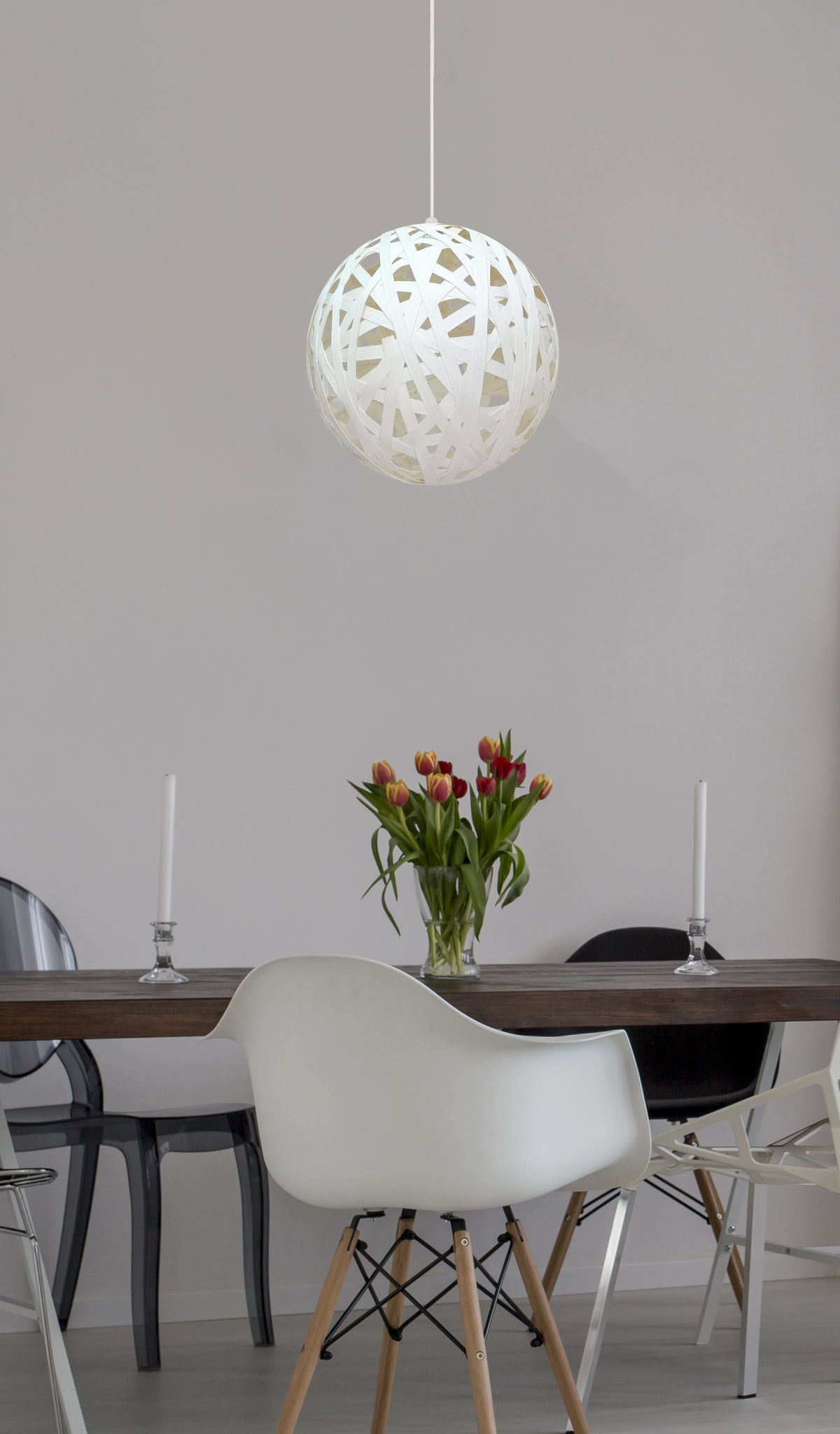 Mise en ambiance du luminaire suspendu au-dessus d'une table de salle à manger fleurie