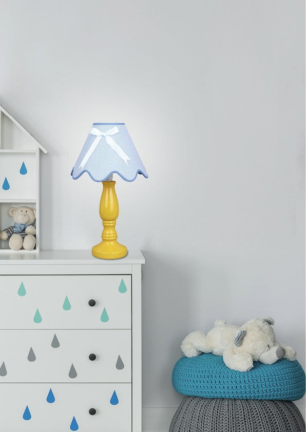 Lampe posée sur une commode blanche dans une chambre d'enfant apaisée