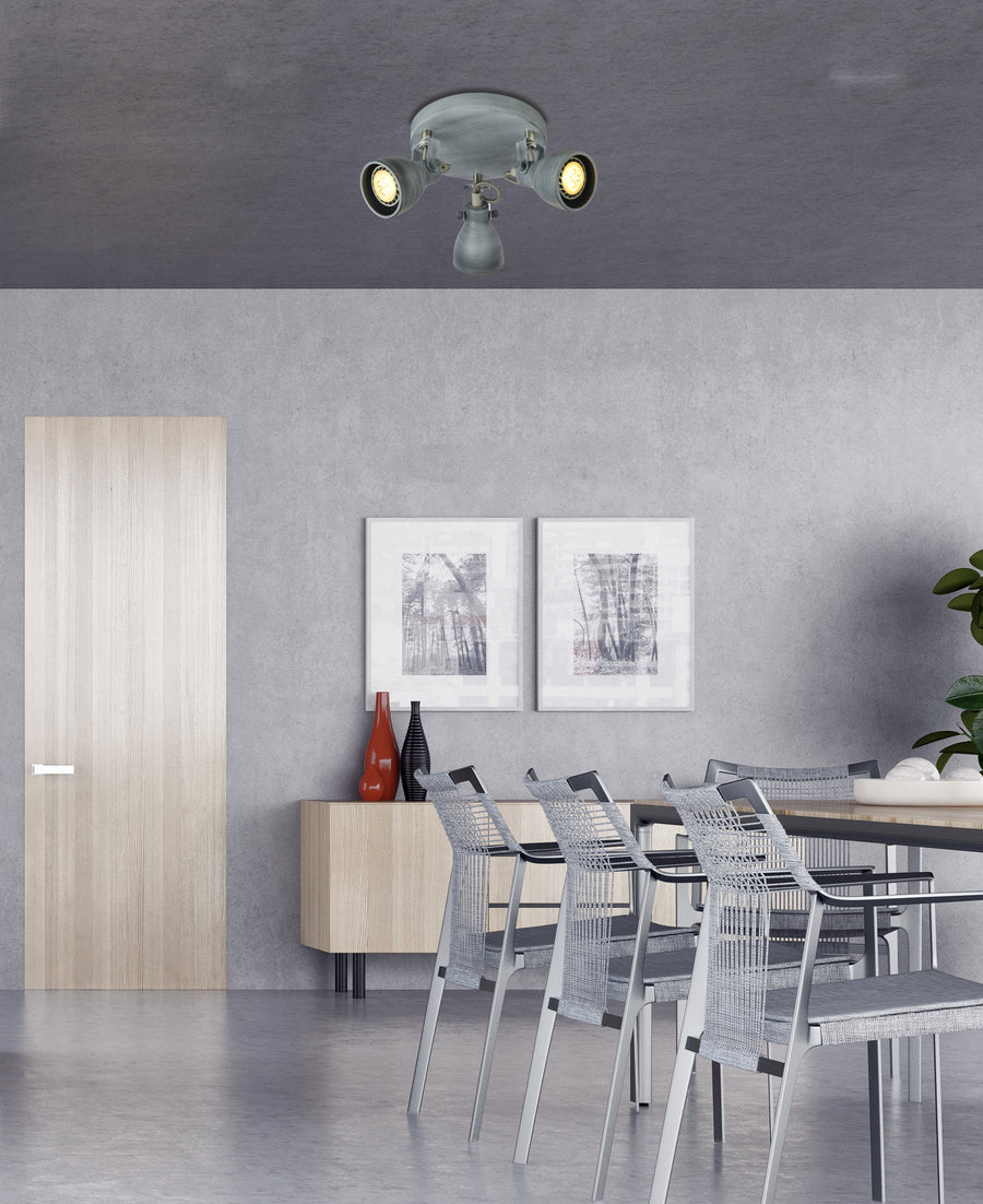 Vue large d'une pièce grise équipée du plafonnier orientable, éclairant une table à manger.