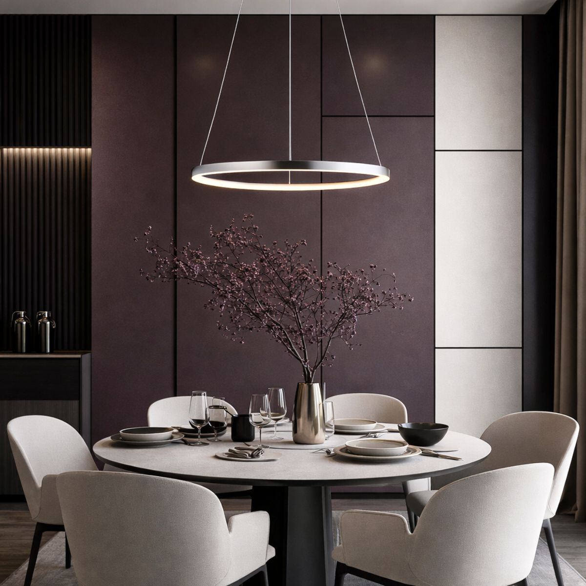 Mise en ambiance au-dessus d'une table ronde dressée dans une salle à manger moderne.