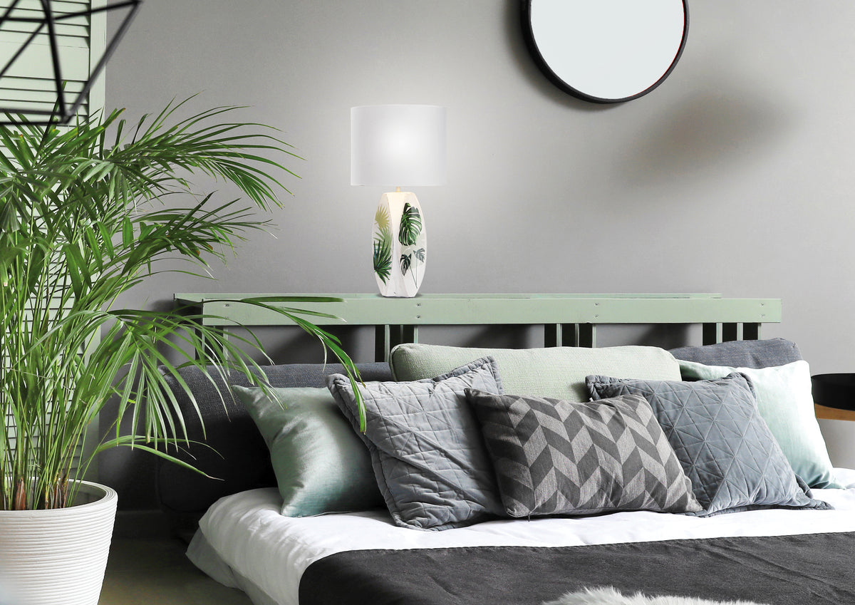 Lampe posée sur l'étagère d'une tête de lit, ambiance chambre végétale grise et verte