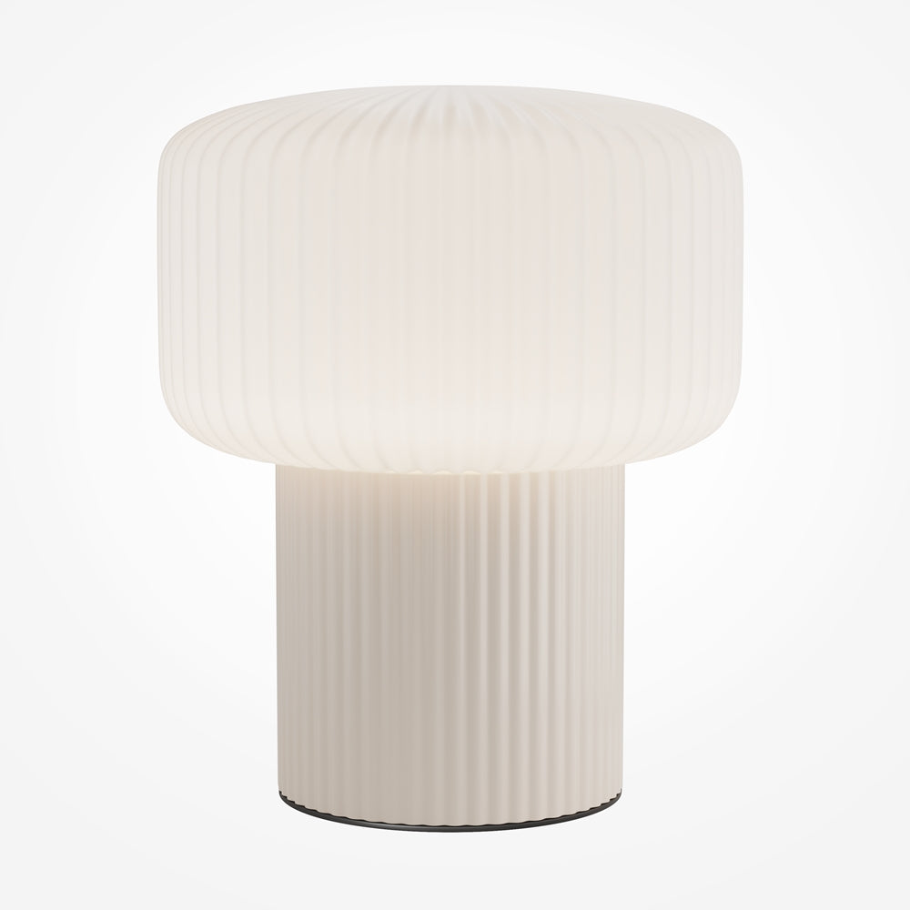 Lampe de chevet beige éteinte, posée de face sur fond blanc, abat-jour cylindrique strié.