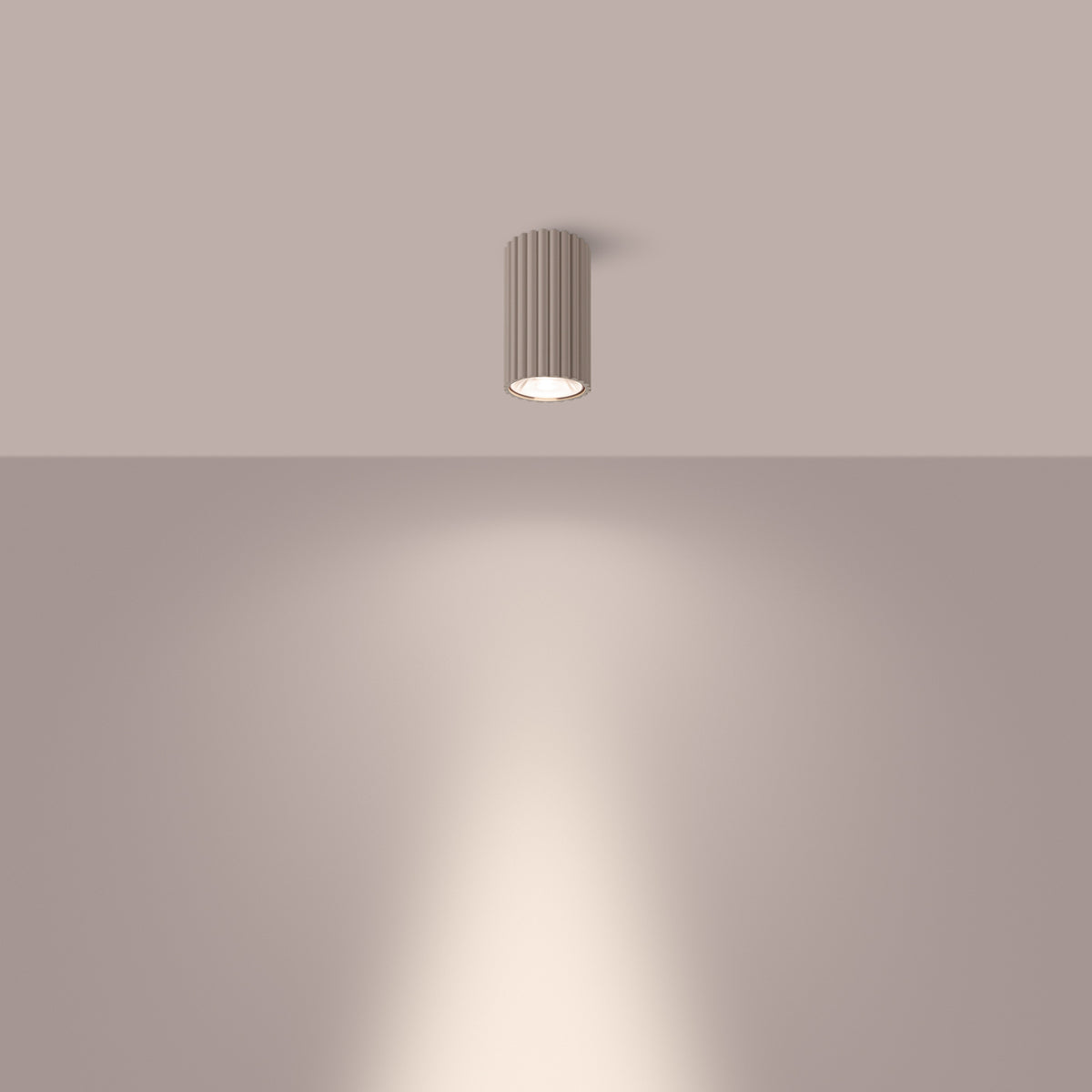 Plafonnier beige allumé au plafond, halo lumineux projeté sur le mur.