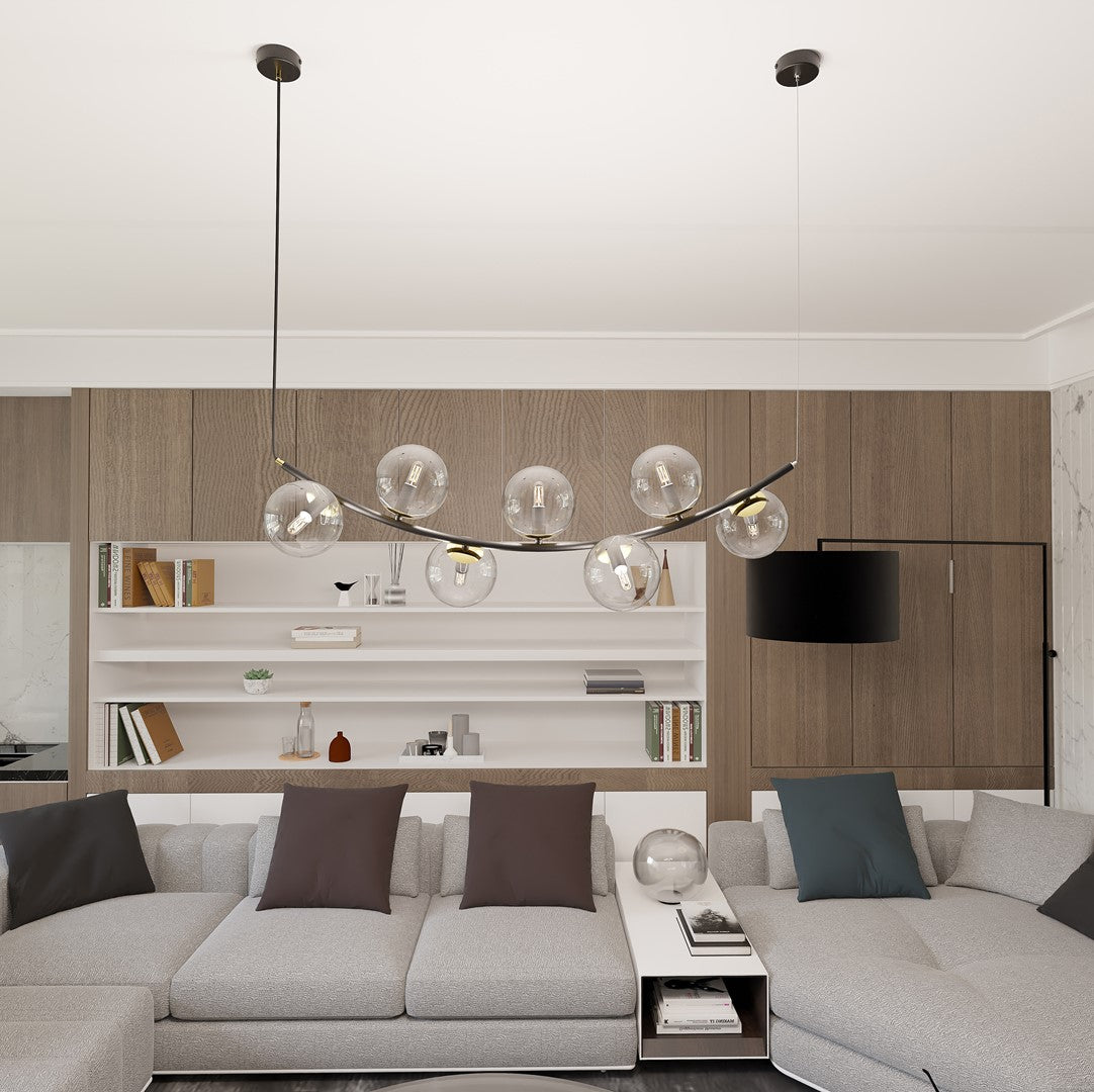 Mise en ambiance au-dessus d'un canapé, suspension allumée dans un séjour contemporain.
