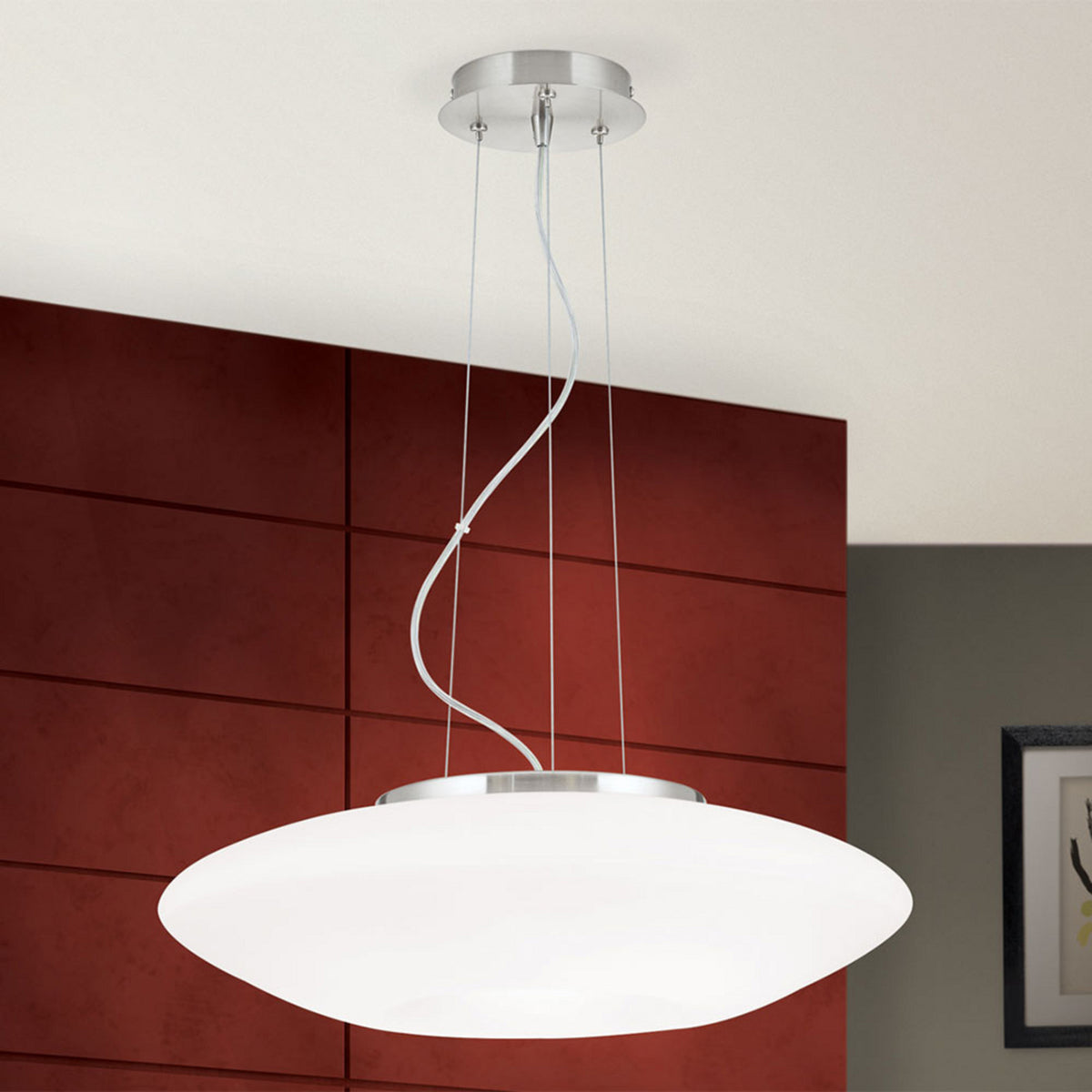 Suspension complète fixée au plafond, diffuseur blanc et câbles fins visibles.