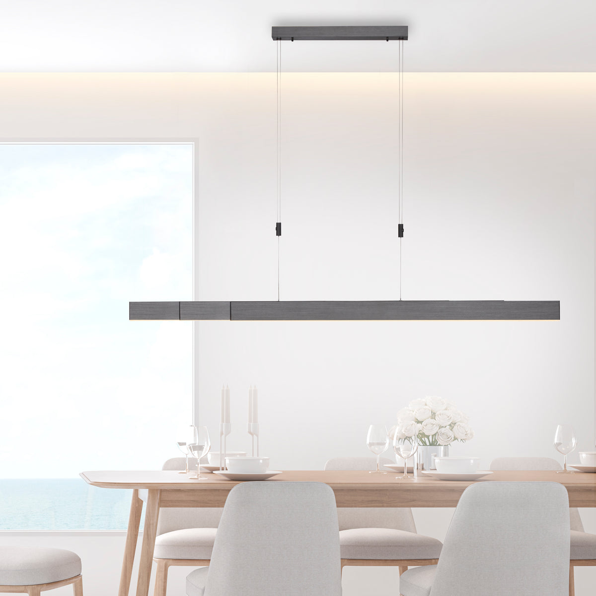 Suspension allumée au-dessus d'une table de salle à manger lumineuse et moderne.
