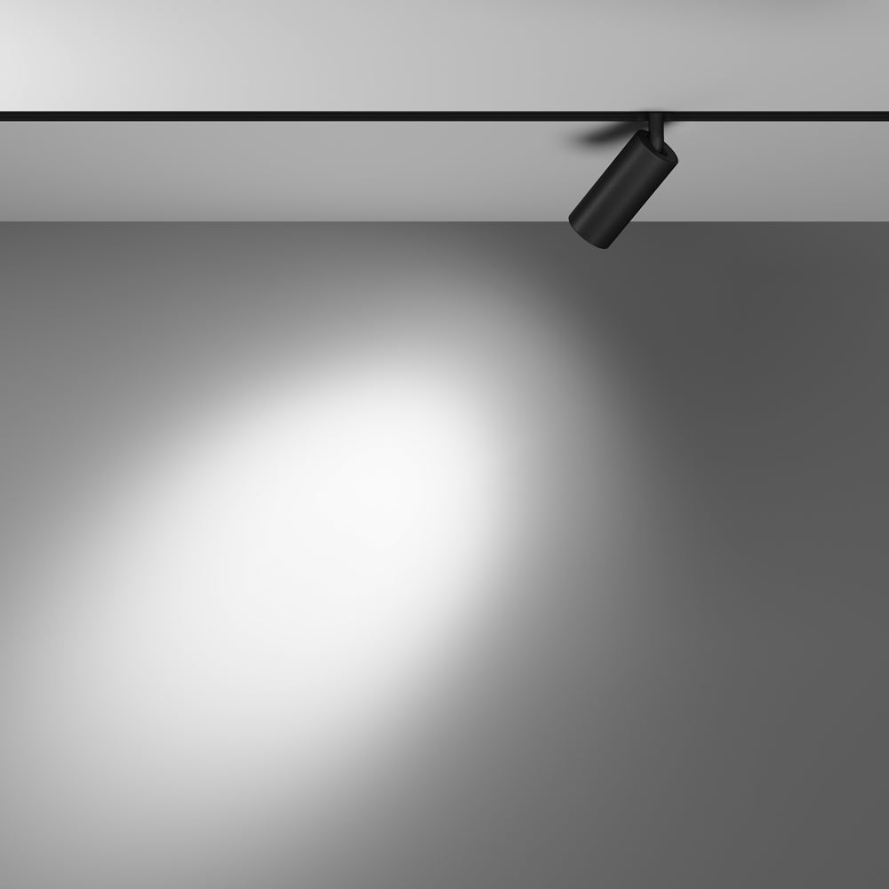 Mise en ambiance : le spot projette un large halo lumineux blanc sur le mur gris.
