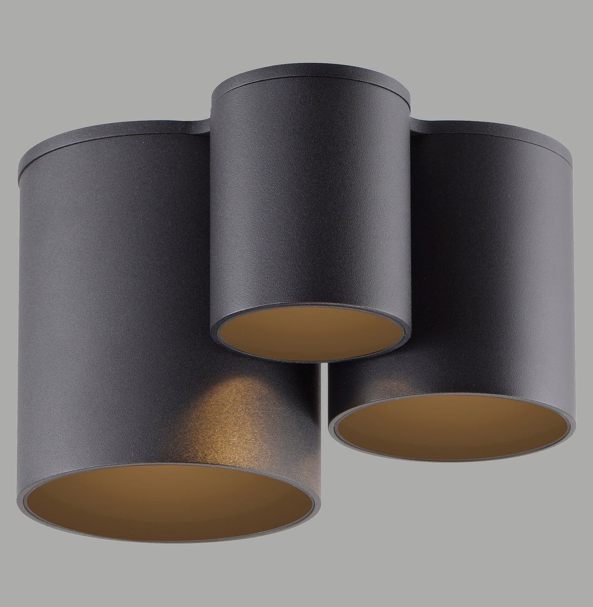 Vue de trois cylindres noirs suspendus, intérieur doré, sur fond gris neutre.