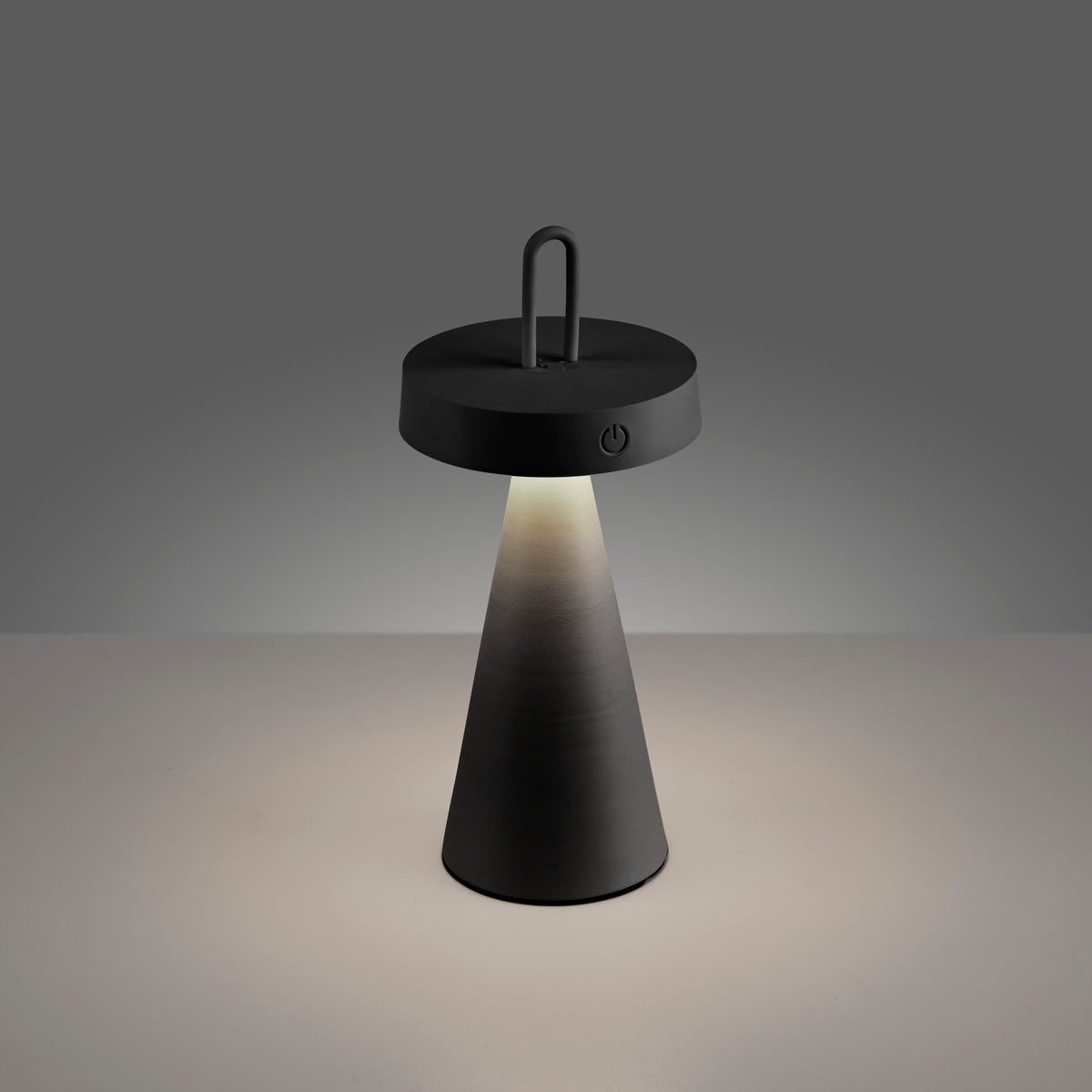 Lampe allumée sur fond clair, halo lumineux et ombre portée.