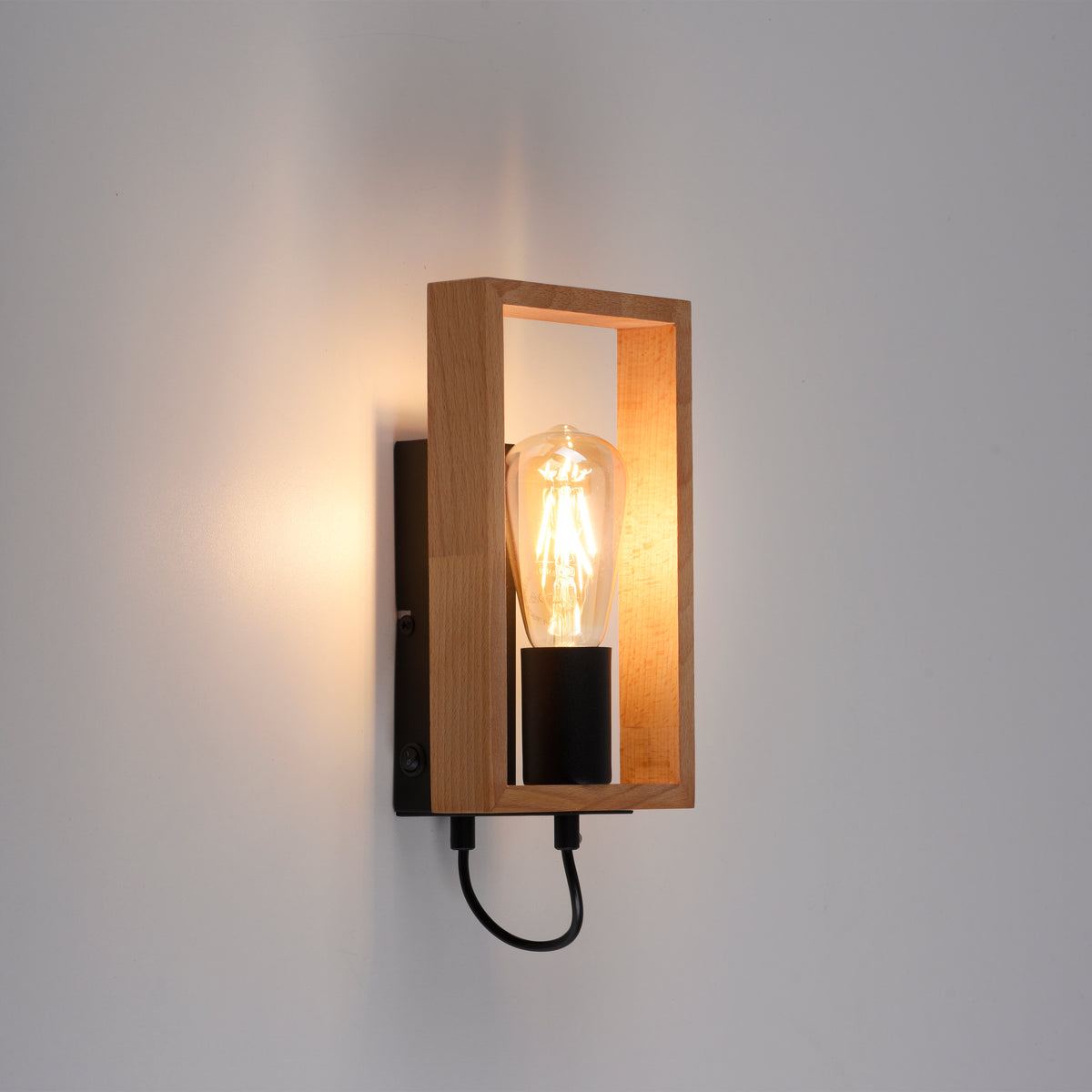 Applique fixée sur un mur blanc, éclairage chaud et ombre portée douce.