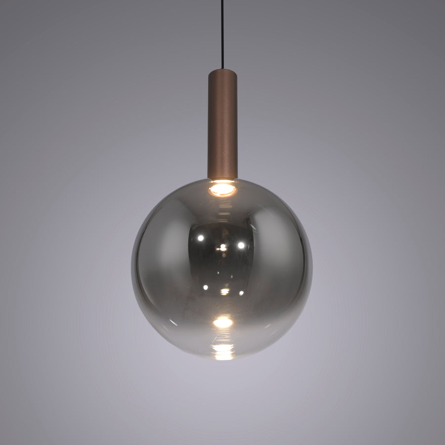 Gros plan sur la boule en verre fumé allumée, reflets et douille cuivrée visible.