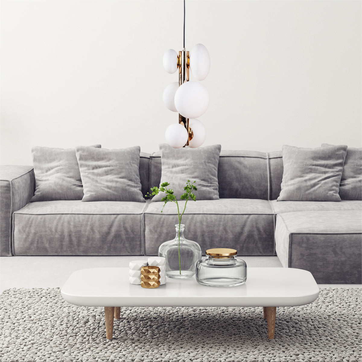 Mise en ambiance du salon avec canapé gris et suspension allumée
