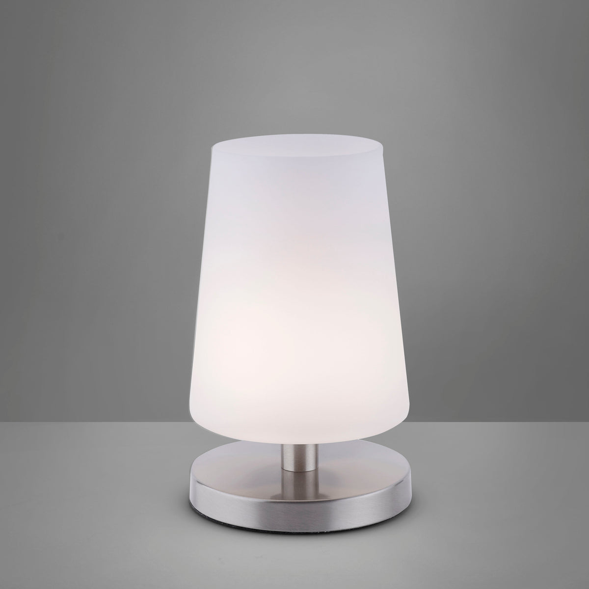 Vue de face sur fond gris anthracite, abat-jour allumé diffusant une lumière chaude