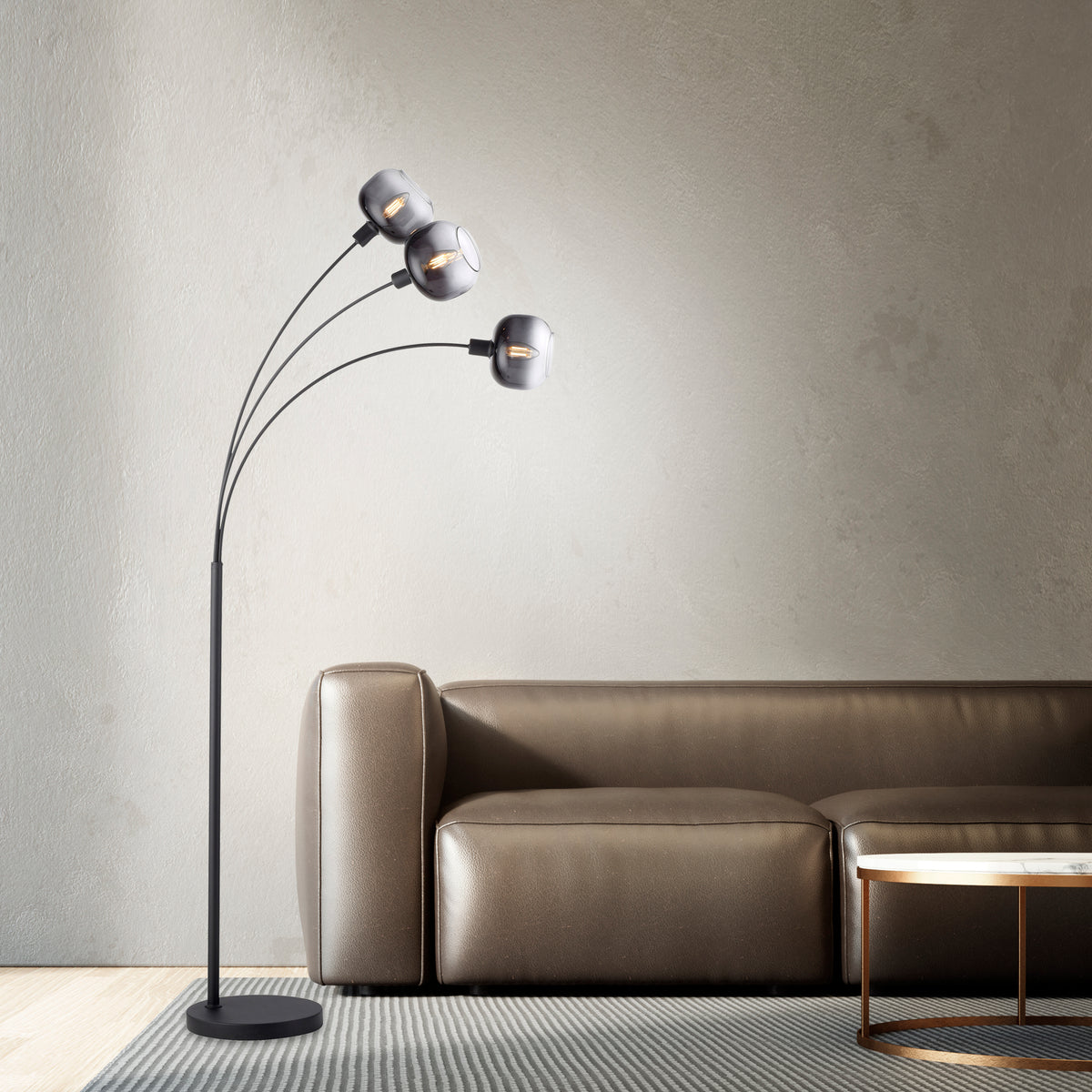 Mise en ambiance salon, lampadaire allumé près canapé cuir taupe