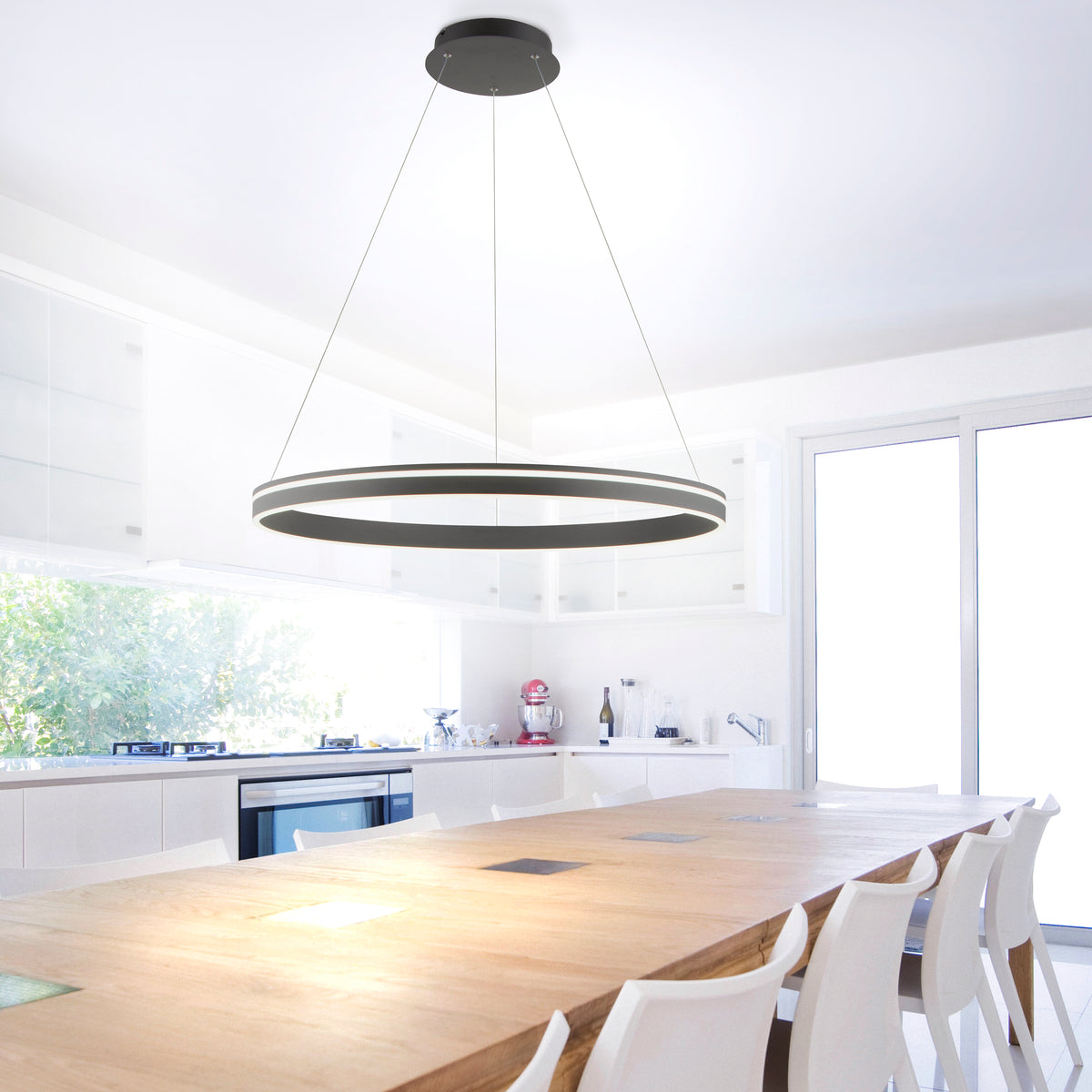 Mise en ambiance au-dessus d'une longue table de cuisine blanche et bois clair.