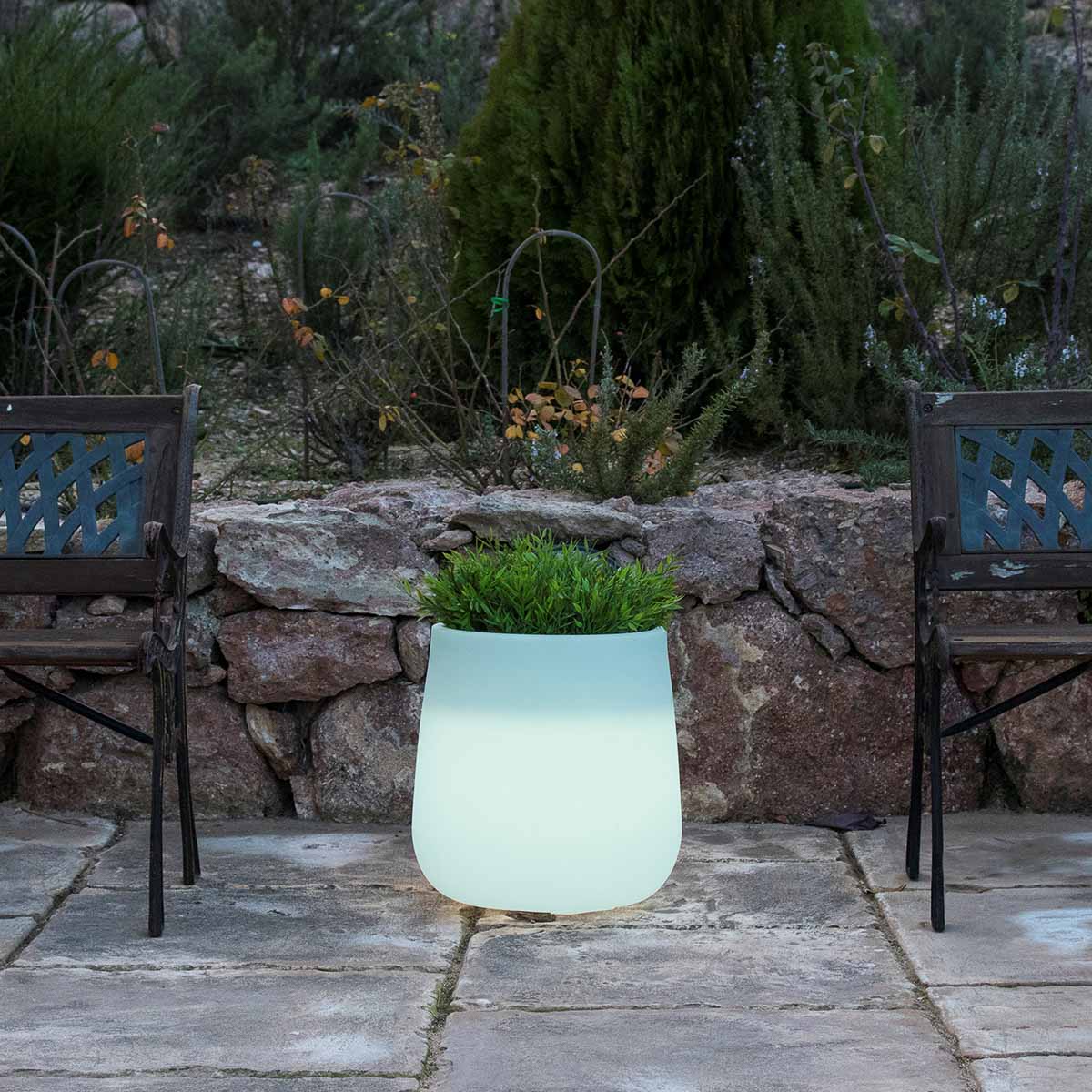 Produit de face : pot lumineux blanc avec plante verte devant un muret