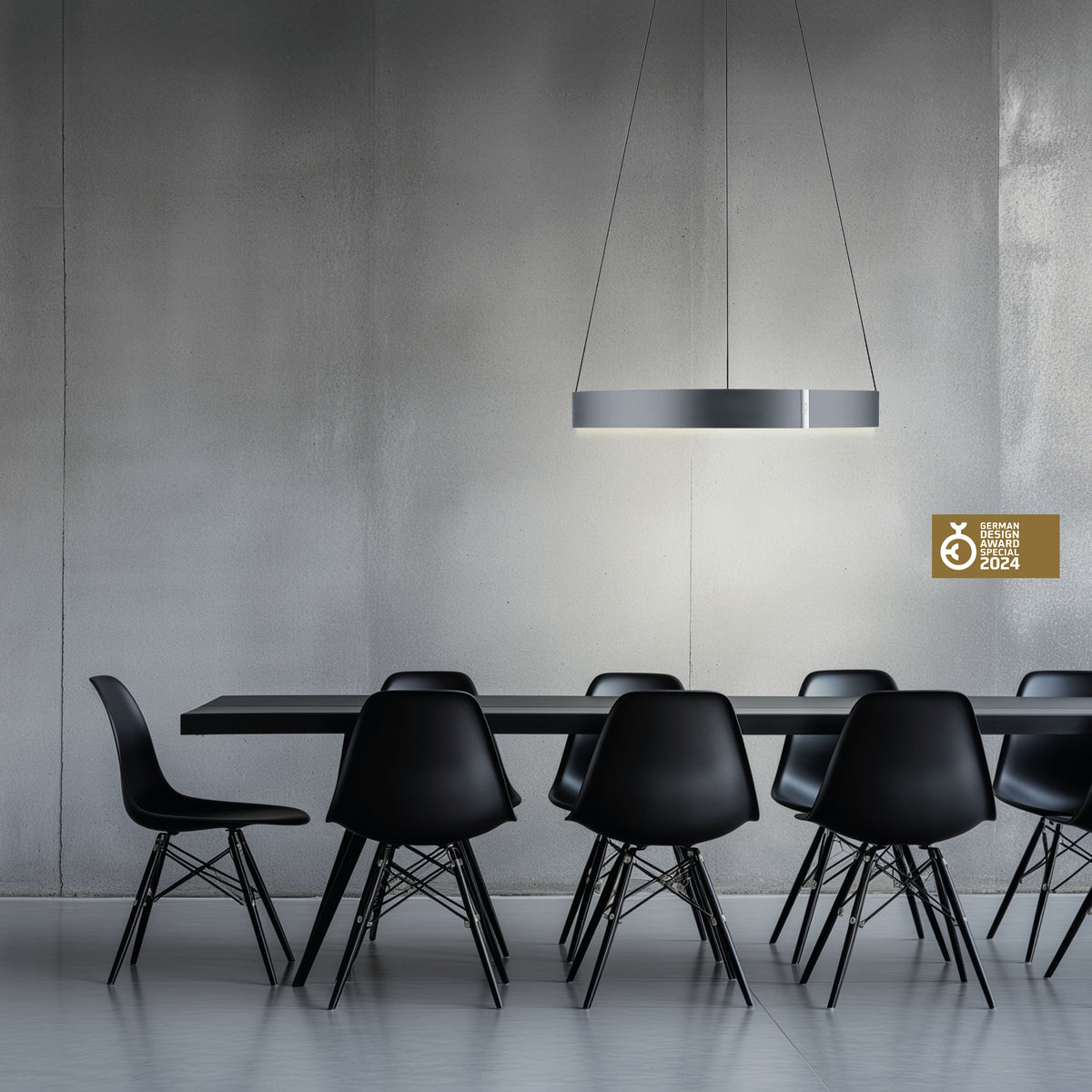 Mise en ambiance au-dessus d'une table noire et chaises design dans pièce béton.