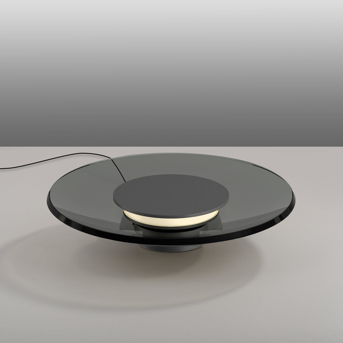 Mise en ambiance sur une table, avec câble apparent et reflet du luminaire éteint.