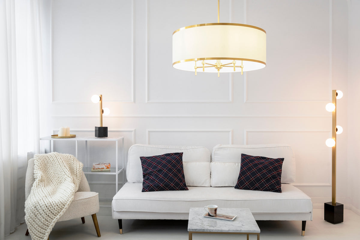 Mise en ambiance dans un salon moderne, lustre allumé au-dessus d'un canapé blanc