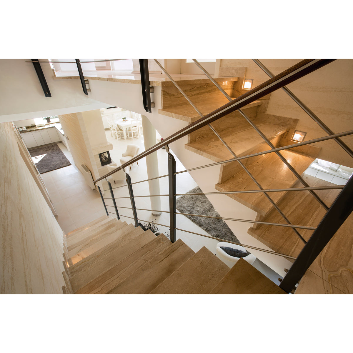 Mise en ambiance : spots encastrés éclairant des marches d'escalier en pierre beige.